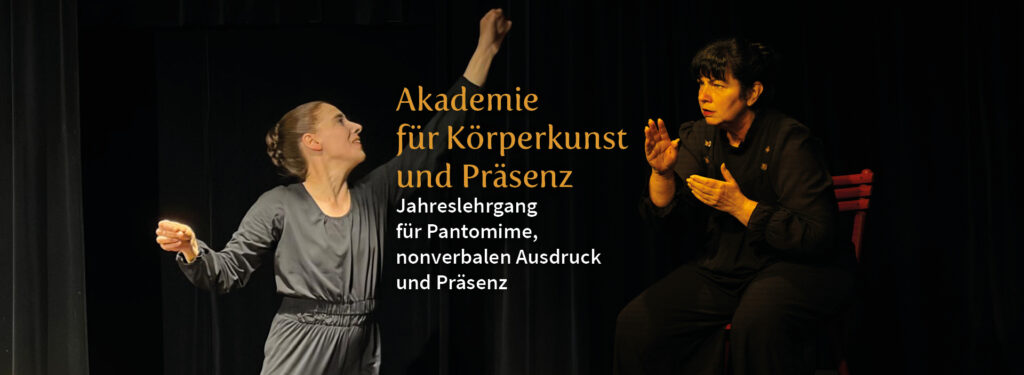 Zwei Personen in einer ausdrucksstarken, nonverbalen Interaktion vor dunklem Hintergrund. Der goldene Schriftzug „Akademie für Körperkunst und Präsenz – Jahreslehrgang für Pantomime, nonverbalen Ausdruck und Präsenz“ hebt sich deutlich ab und unterstreicht die künstlerischen Schwerpunkte des Lehrgangs. Das Bild vermittelt die Intensität und den emotionalen Ausdruck der darstellenden Kunst.