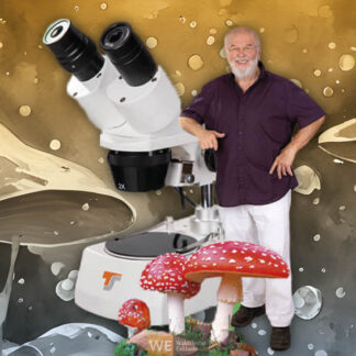 Dkfm. Franz Müller neben einem überdimensional großen Mikroskop und Fliegenpilzen
