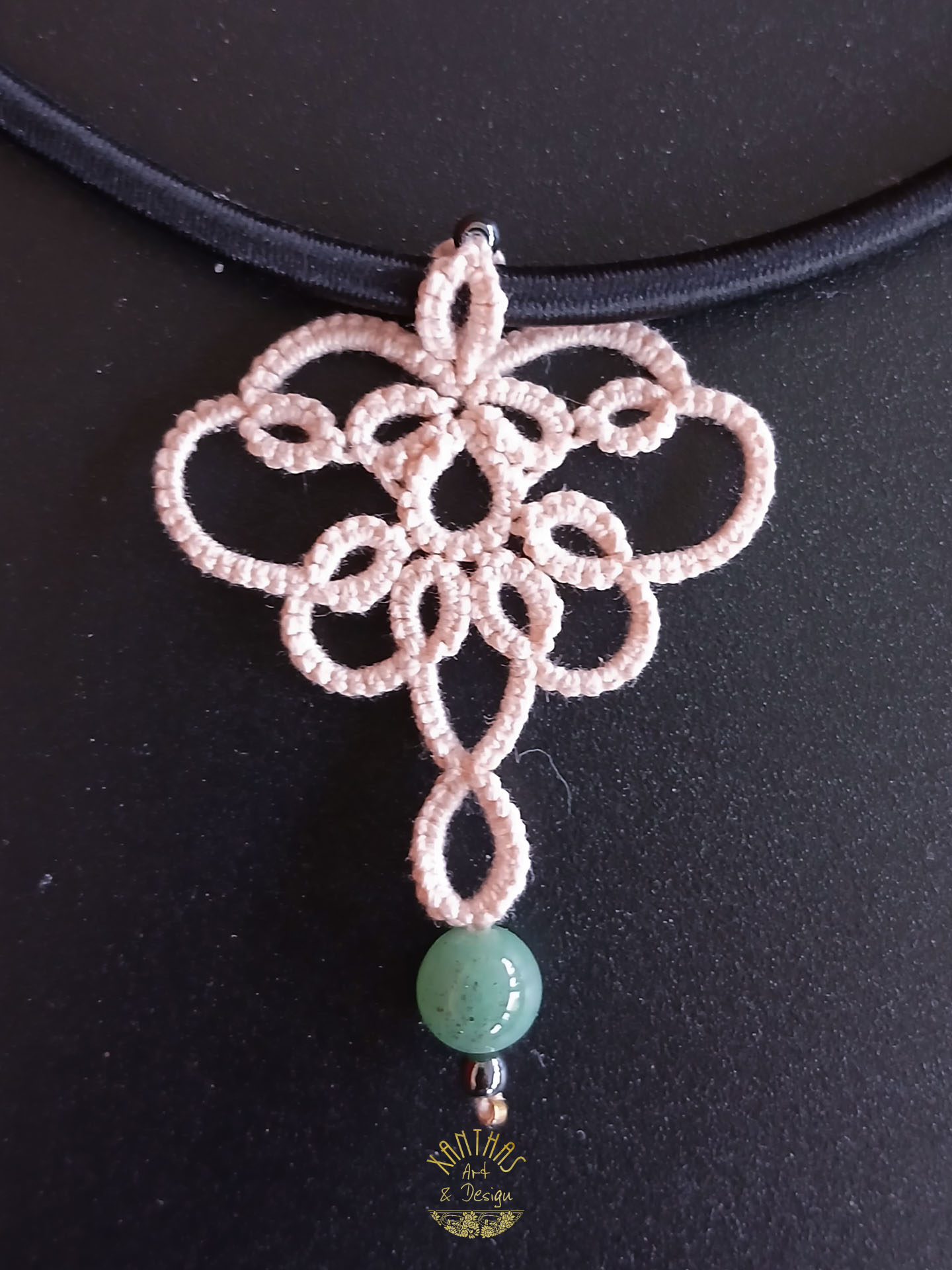 Collier „Patricia“ aus handgefertigter Frivolitätenspitze in Zartrosa/Lachs mit grüner Halbedelsteinperle, Hämatitperlen und goldfarbigem Rocaille. Kombiniert mit einer schwarzen Textilhalskette mit silberfarbenem Karabinerverschluss und Verlängerungskette.