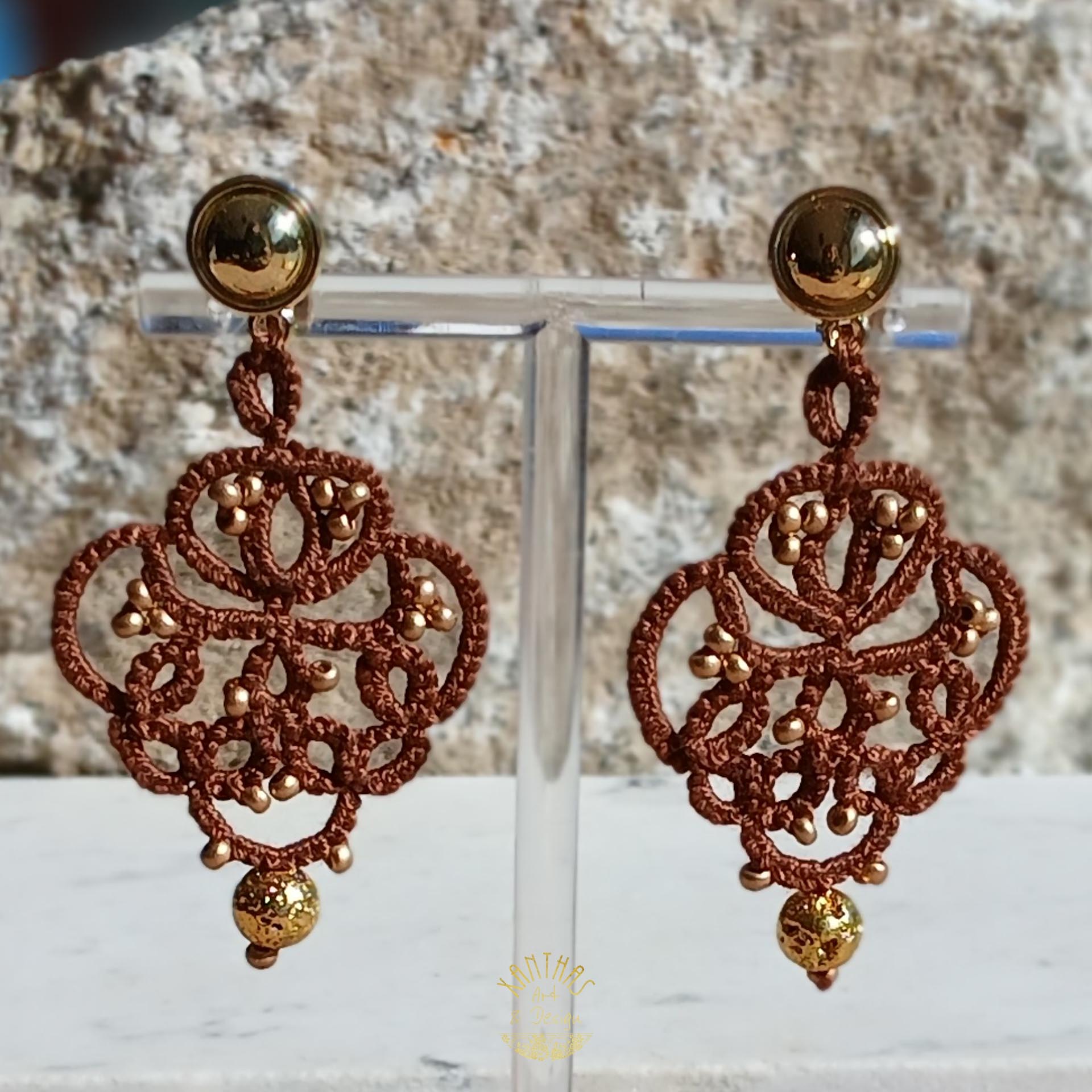 Ohrclips „Amandine“ aus handgefertigter Frivolitätenspitze in Dunkelbraun mit gold bedampften Rocailles und gold galvanisierten Lavaperlen. Die Ohrclipspatente sind aus goldfarbigem Metall.