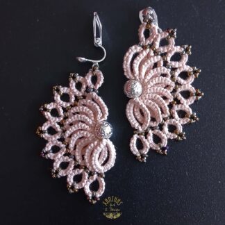 Ohrclips „Clio“ aus handgefertigter Frivolitätenspitze in Zartrosa/Lachs mit halbmondförmigem Design, silber galvanisierter Lavaperle in der Mitte und bronzefarbigen Rocailles. Die Ohrclips sind aus 925 Sterling Silber.