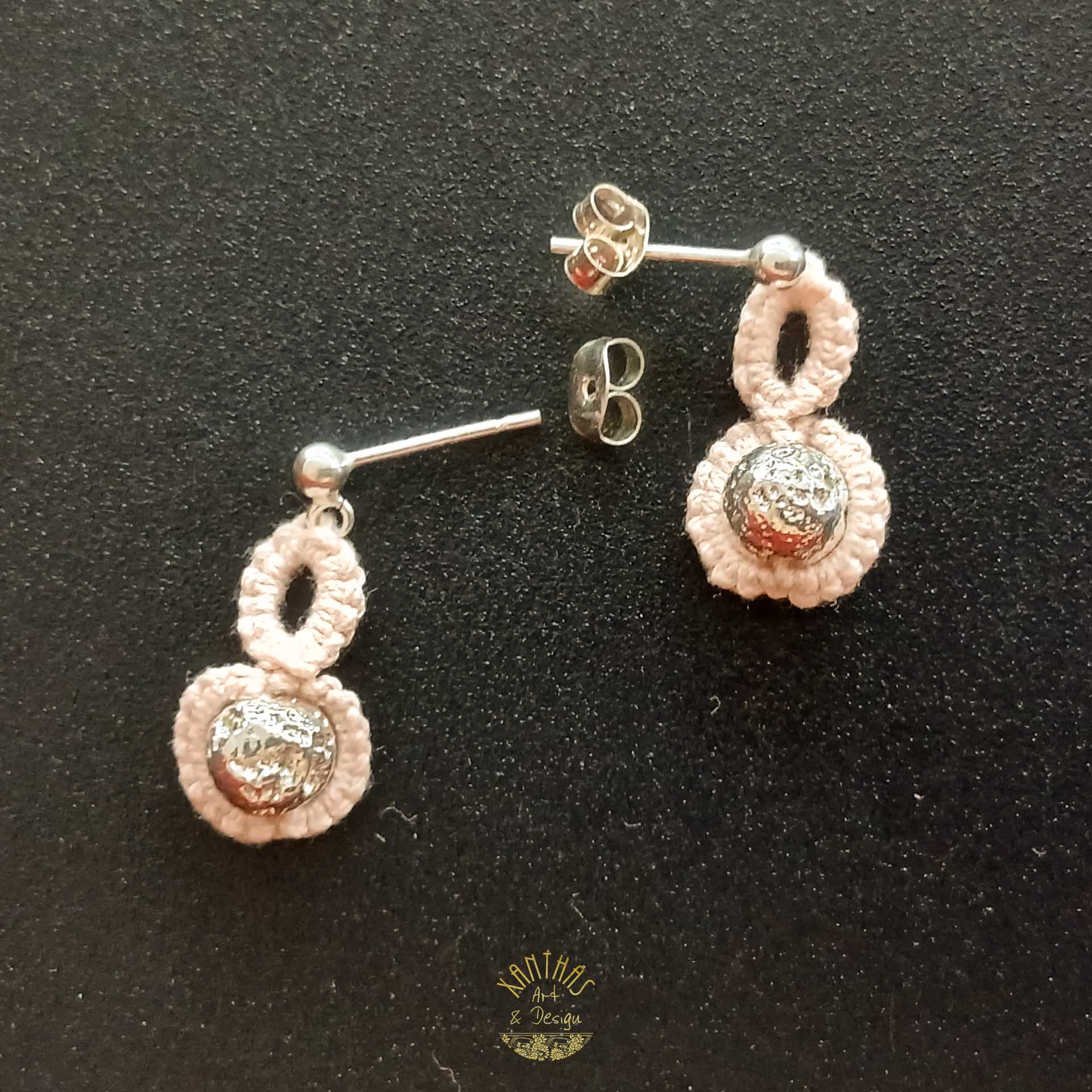 Handgefertigte Ohrstecker „Adriana“ aus zartrosa/lachsfarbigem Baumwollgarn in Frivolitätenarbeit (Schiffchenspitze). Hauptmerkmal ist die silber galvanisierte Lavaperle, die mit Schiffchenspitze umarbeitet ist. Die Ohrstecker sind aus 925 Sterling Silber.